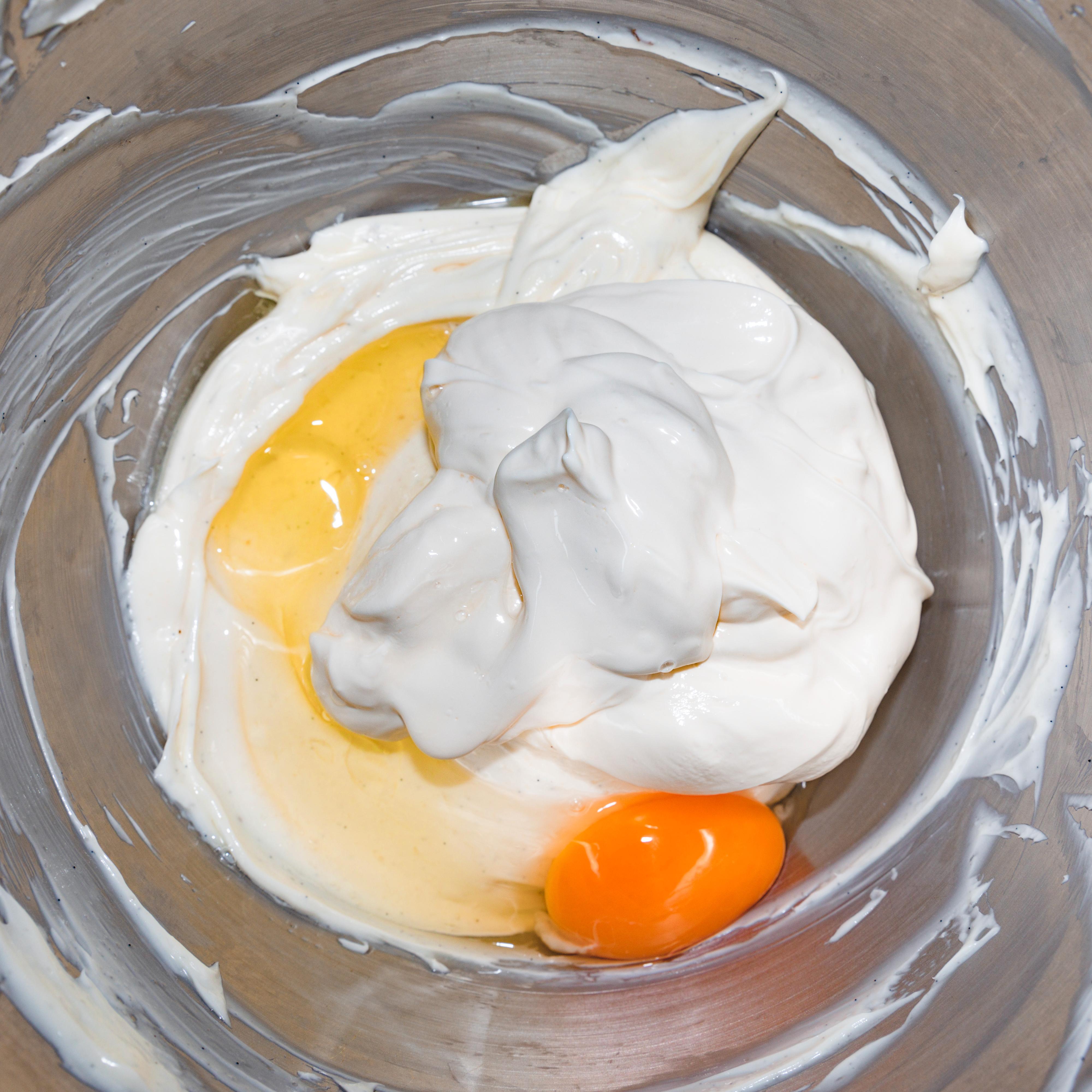 Bruk en kjøkkenmaskin og rør osten glatt og kremet. Visp gradvis inn sukkeret ved lav hastighet. Skrap ned langs kantene, tilsett frøene fra vaniljestangen og rømme. Visp alt godt sammen og visp inn ett og ett egg og eggeplommen. Ikke rør for mye etter at eggene er tilsatt.