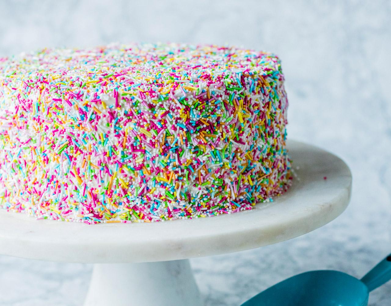 Del hver kake i to jevne lag. Bygg kaken med litt krem mellom hvert lag, pass på at du har nok krem igjen til å dekke hele kaken til slutt. 