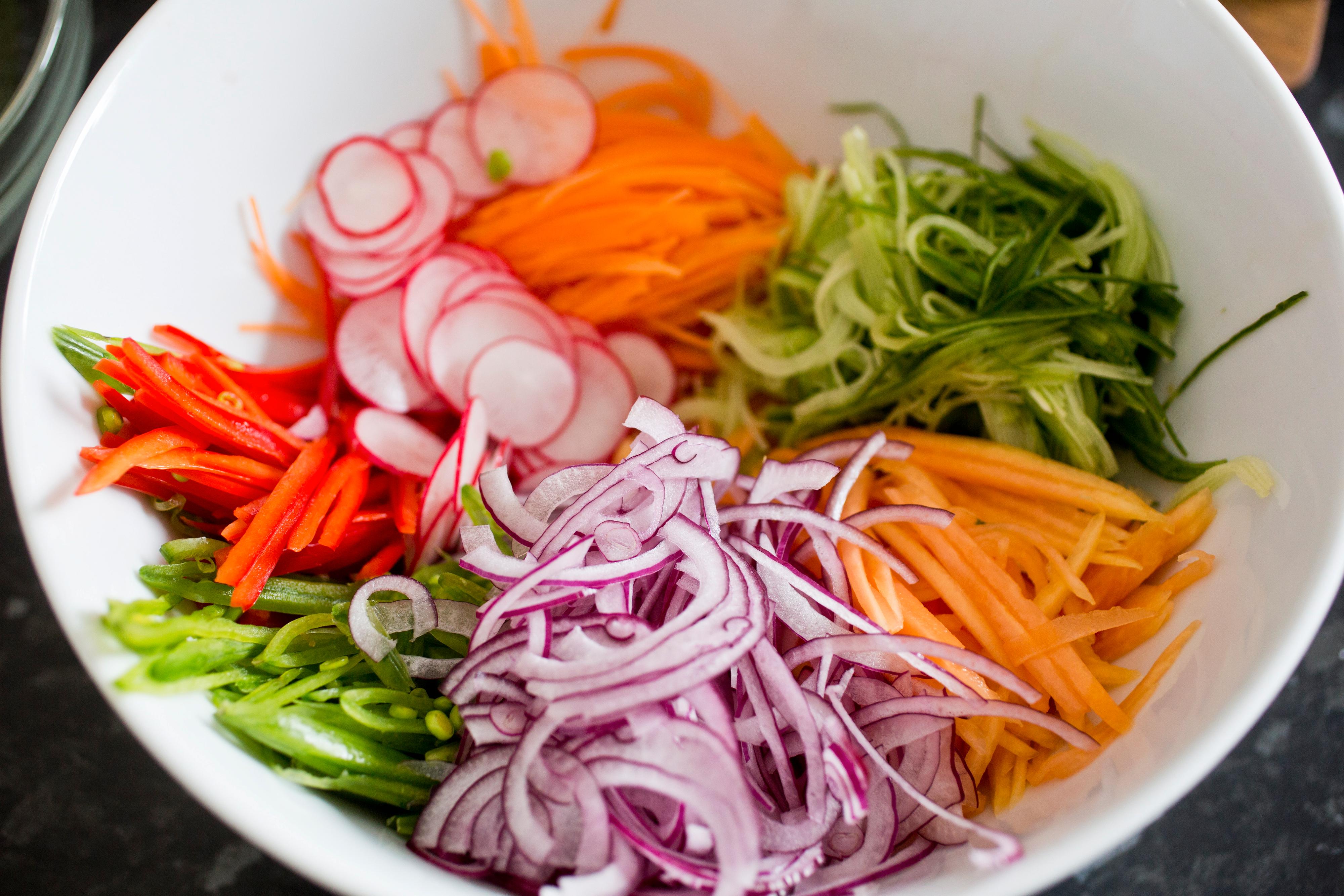 Skjær reddikene i tynne skiver. Bland alle grønnsakene i en bolle og tilsett dressing og friske urter.