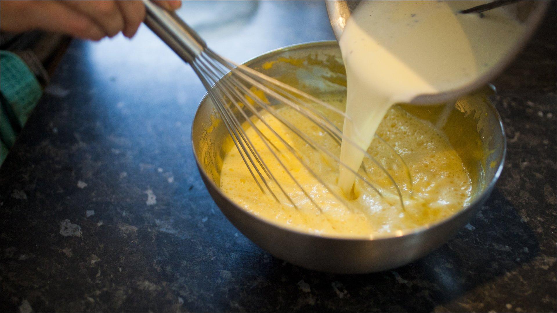 Hel den varme fløtemelken over eggeplommene mens du visper. Hell alt tilbake i kasserollen og varm blandingen forsiktig opp under stadig omrøring. Blandingen skal tykne, men må ikke koke.