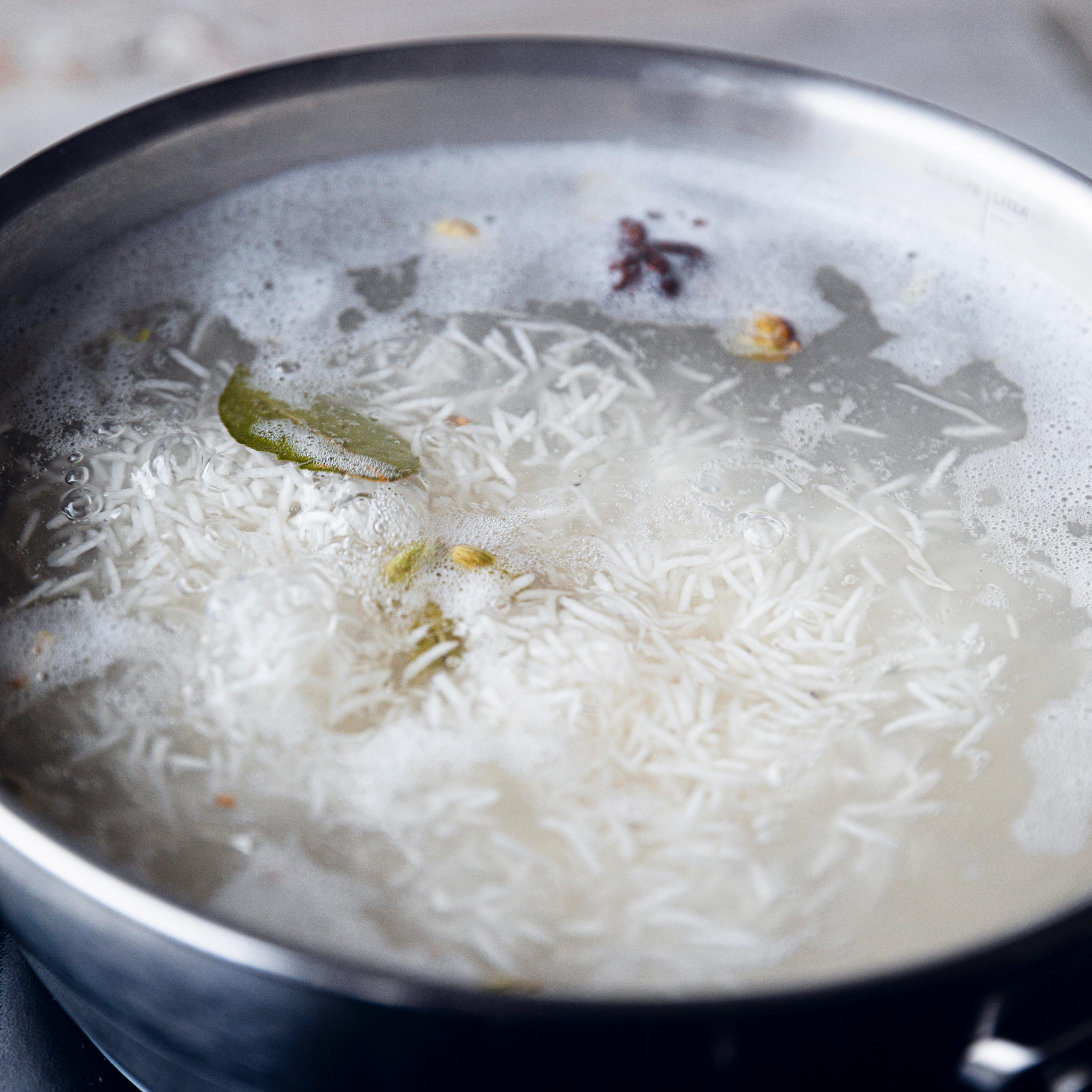 Kok opp vann med kardemomme, stjerneanis, laurbær, nellik, pepper og en god klype salt. Hell bløtevannet av risen, og ha risen over i det kokende vannet. La risen koke i 6-8 minutter, og hell risen over i en sil.