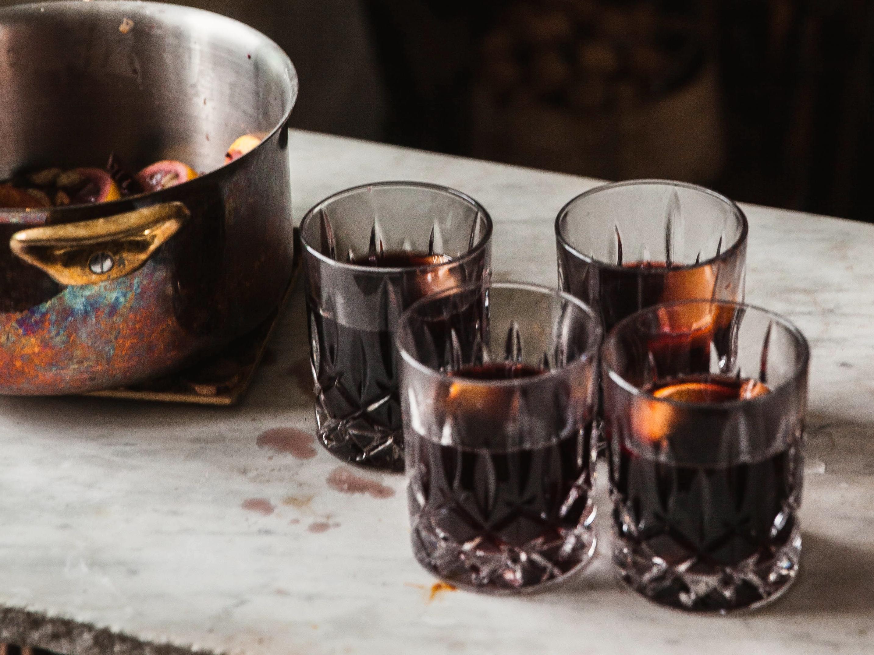 Fire glass med mulled wine står ved siden av en kobbergryte