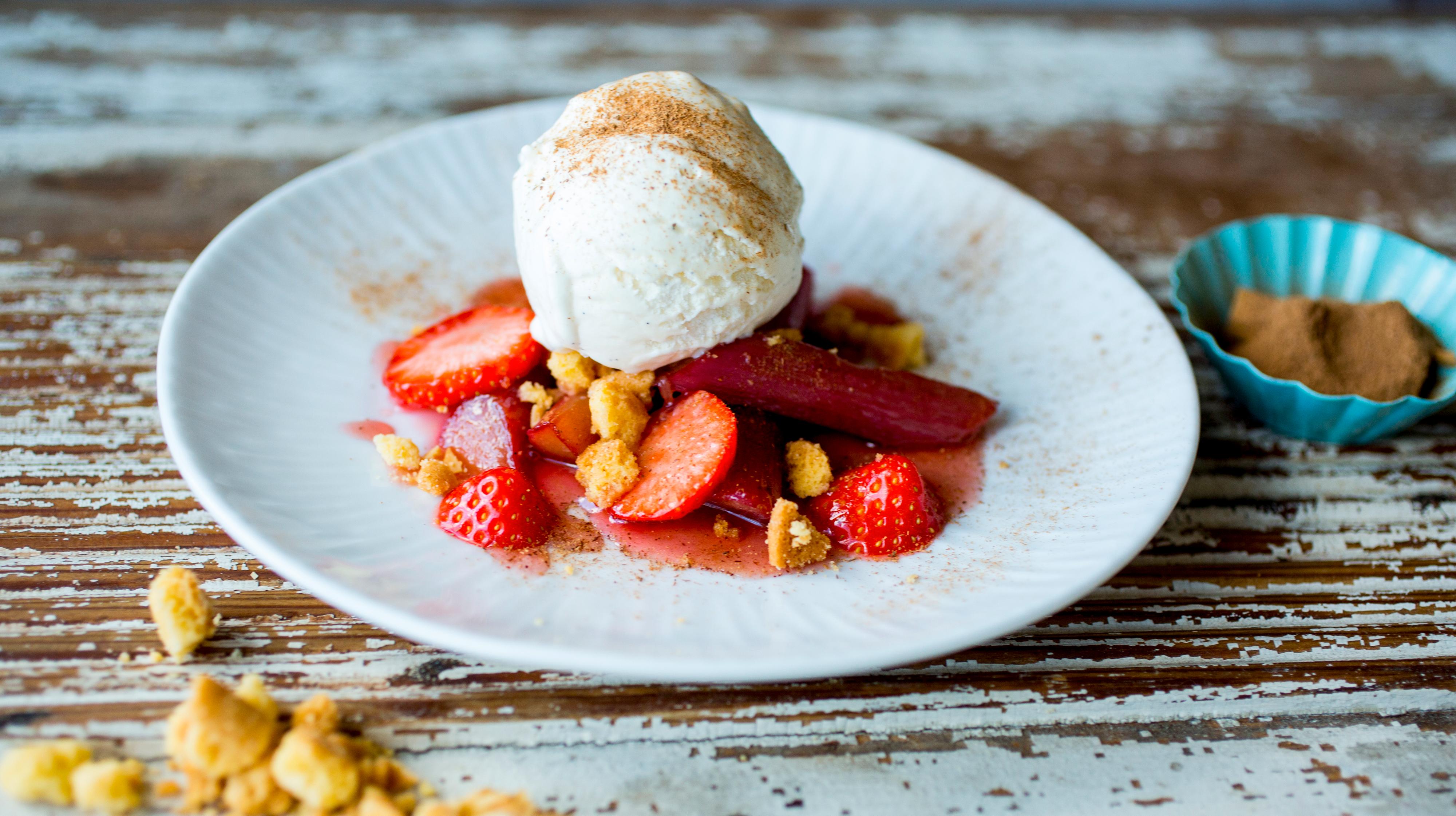 karamellisert rabarbra med jordbær, is og kanel på hvit tallerken