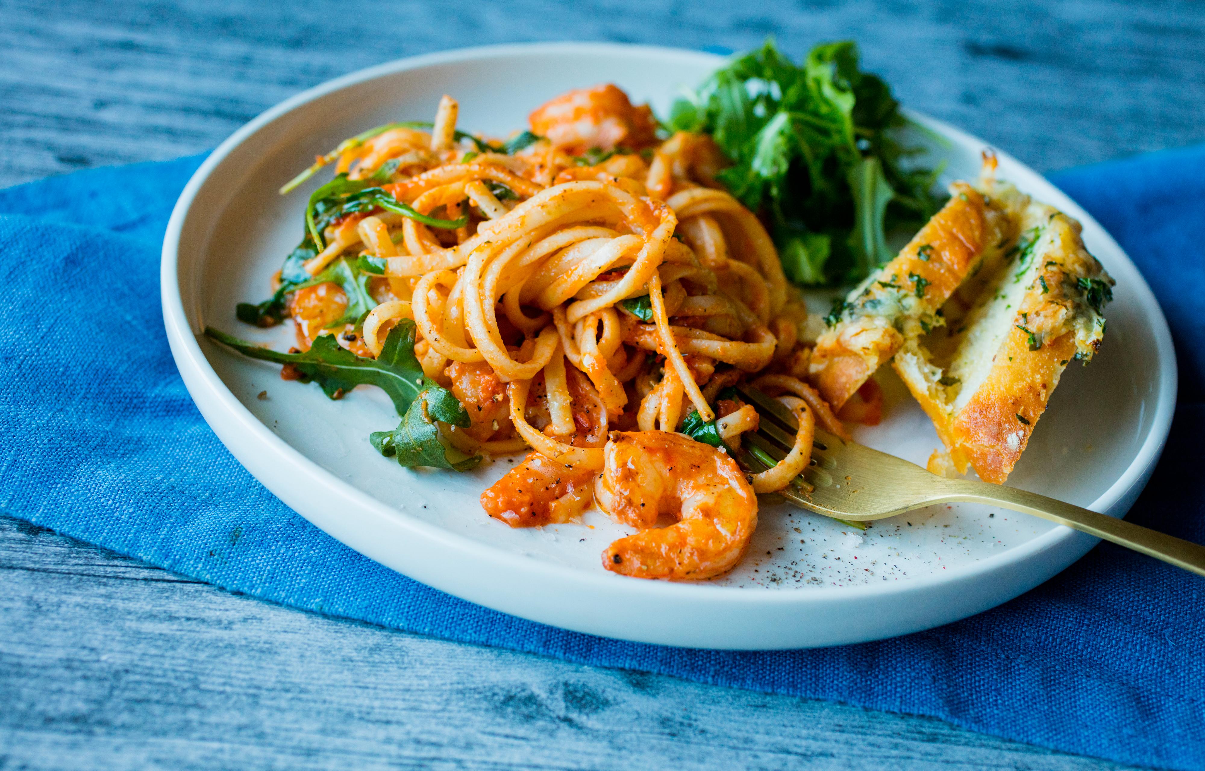 Pasta alla vodka med reker og ruccula på hvit tallerken