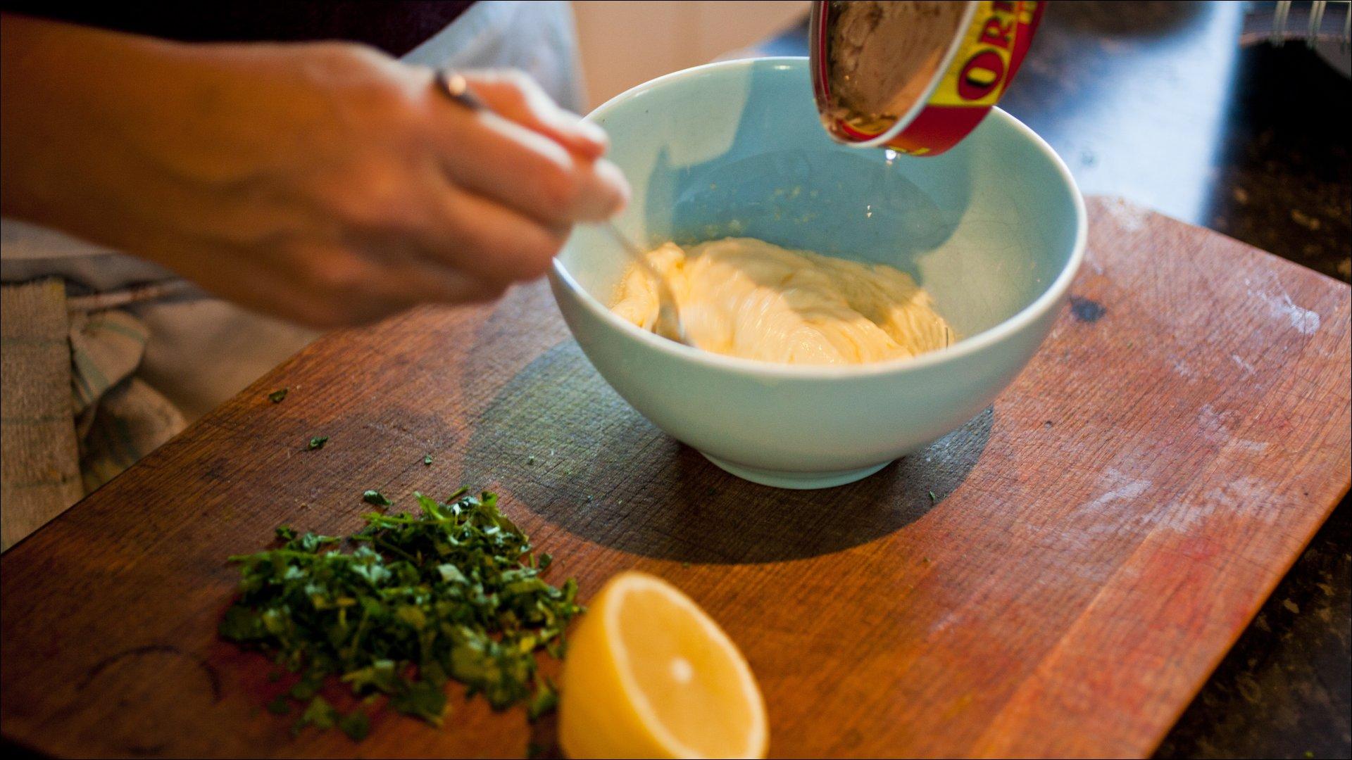 Ha majonesen i en bolle, visp inn oljen fra tunfisken og sitronsaften. Bland inn tunfisken, mos det sammen med en gaffel og rør inn persillen.