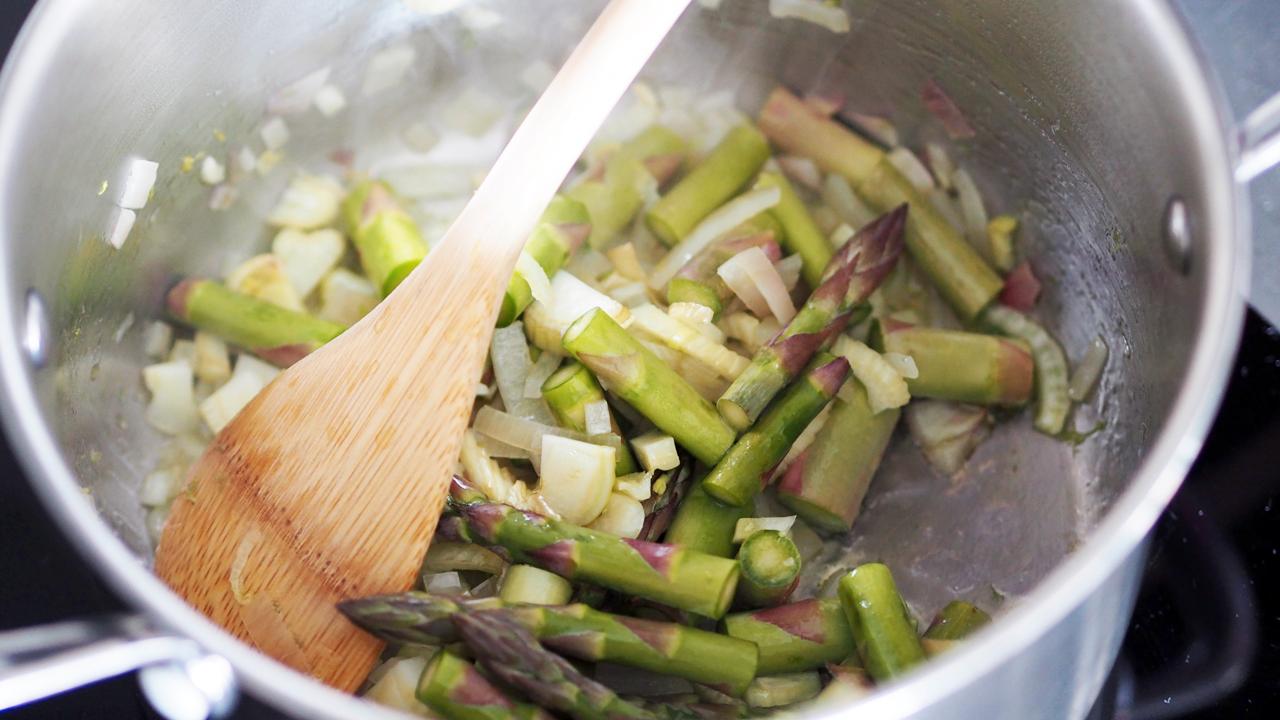 Vask aspargesen og knekk av den nederste delen. Legg til side 2-3 asparges til topping. Del aspargesen i mindre biter og ha det over i gryta. Hell over kraften og gi det et oppkok. Skru ned temperaturen og la det småputre i ti minutter.