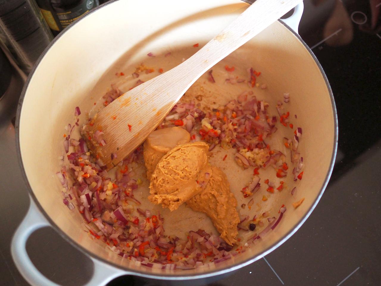 Finhakk rødløk, chili, hvitløk og ingefær. Varm opp litt olje i en stor gryte. Surr ingrediensene i ca. 5 minutter, eller til det har blitt mykt og blankt, og begynner å lukte godt. Tilsett kanel, paprika og peanøttsmøret. Rør det godt sammen.