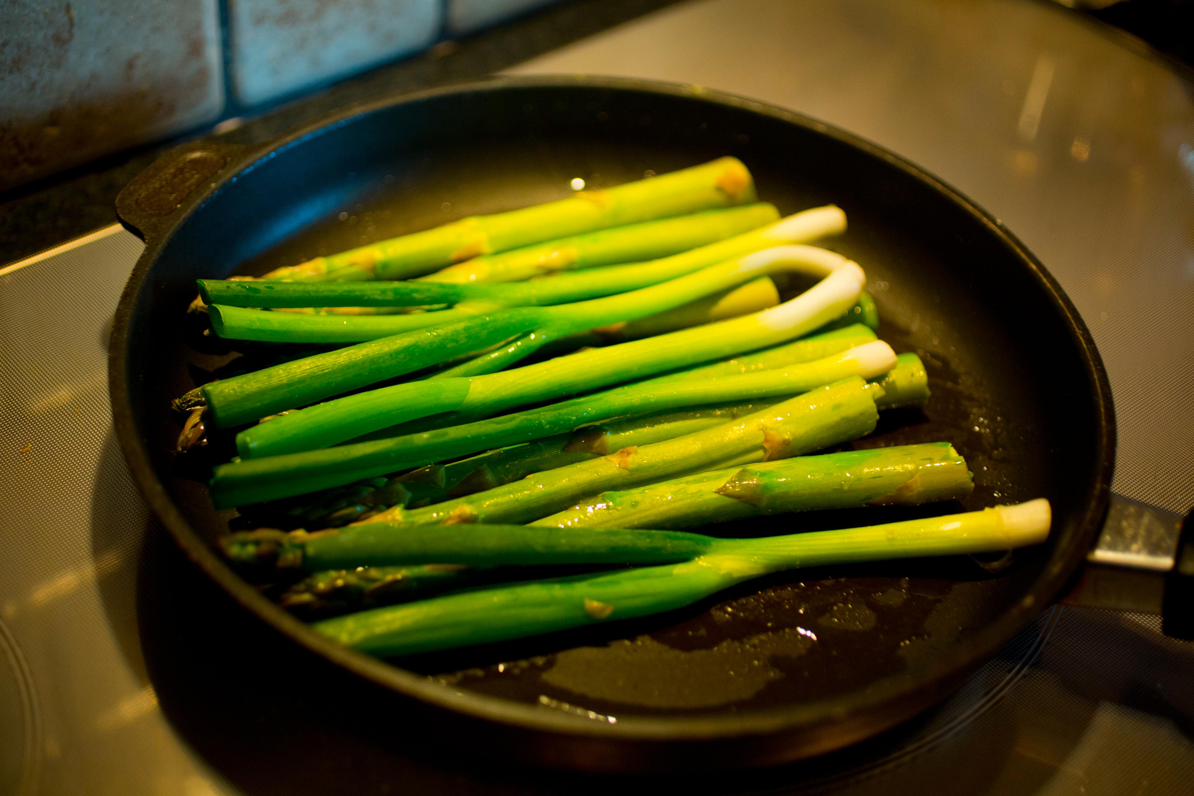 Stek aspargesen et lite minutt i en stor varm stekepanne. Legg i vårløken mot slutten og løft alt over på en tallerken så lenge.