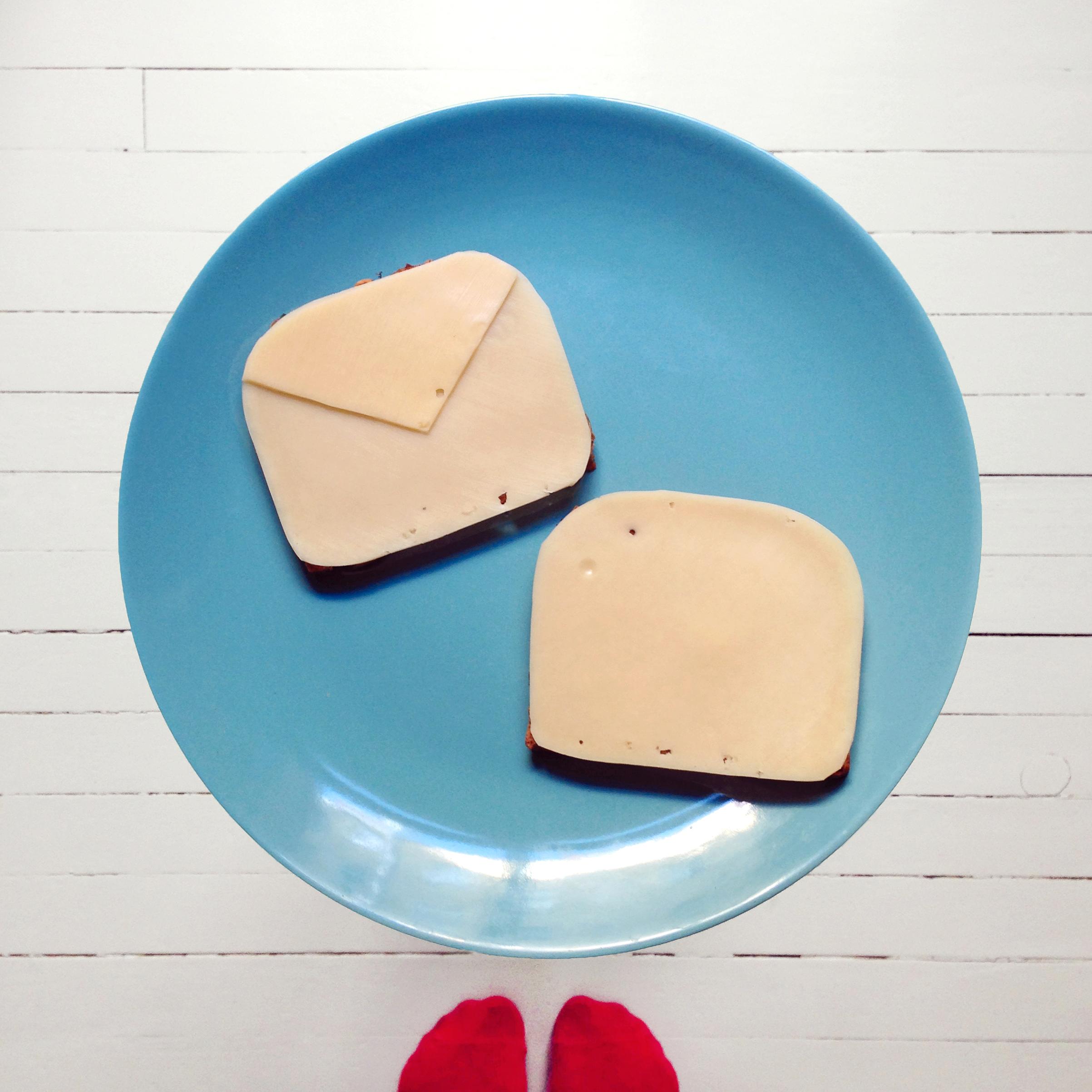 Skjær til osteskivene så de passer på brødskivene. For konvolutten er det to lag, en hel skive med en tilkuttet trekant over, mens «brevarket» kun trenger en hel skive.