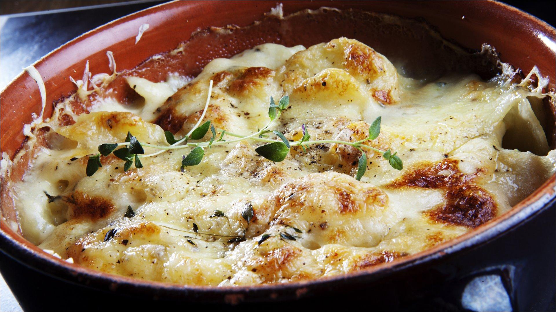 Rens potetene og del dem opp i tynne skiver. Kok opp melk og fløte i en kjele, legg i potetskivene og finhakket hvitløk. Rør rundt, slik at de ikke brenner seg fast i bunnen av kjelen. La potetene kokes lett møre i fløtemelken før halvparten av osten røres inn. Tøm potetene over i ildfast ovnsform, dryss over resten av osten. Gratiner potetene i ovnen på 180 grader i ca. 20-30 minutter til osten er gyllen. Skrell aspargesstilkene, smørdamp møre i vann tilsatt litt smør.