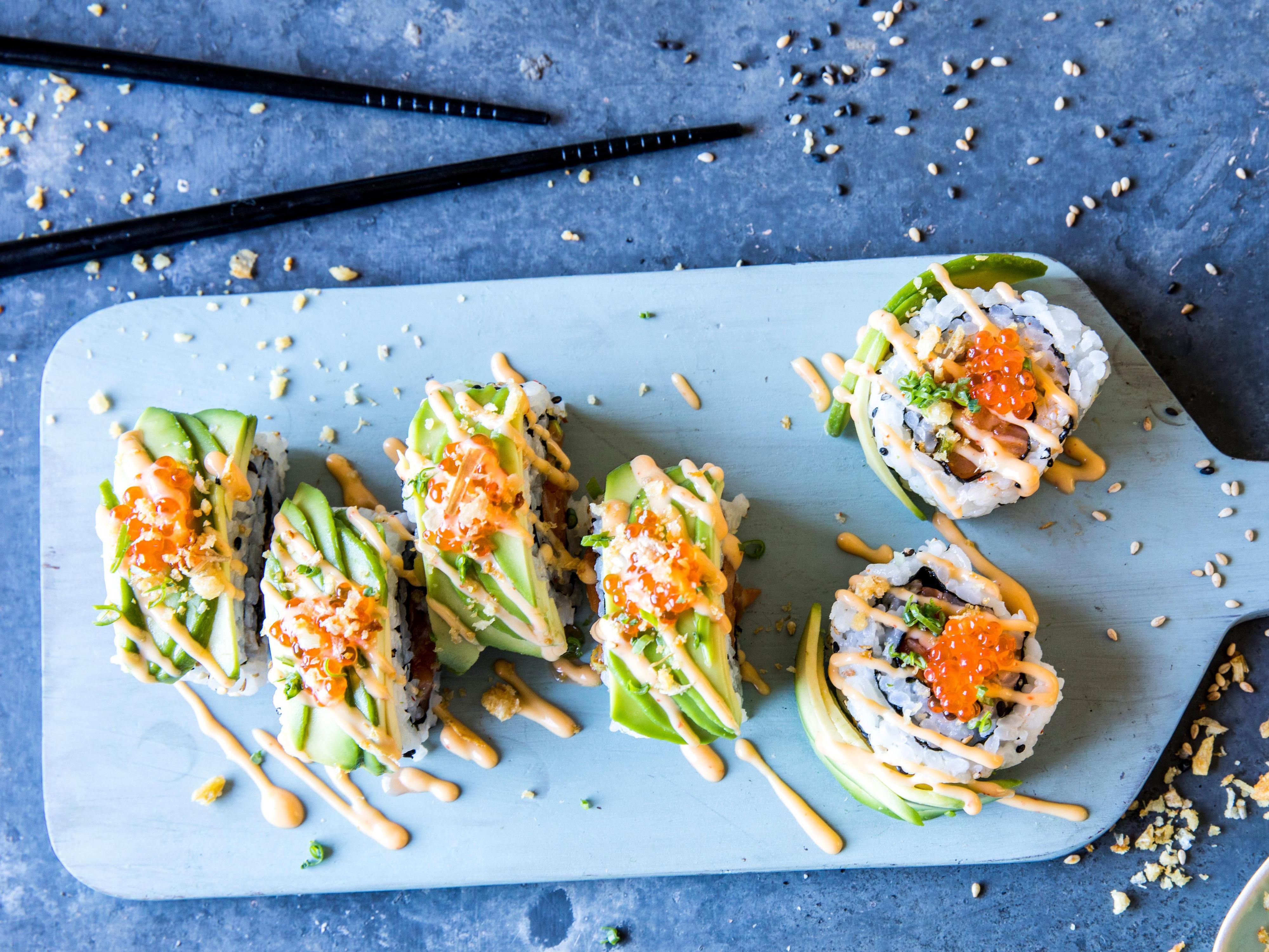 Maki sushi kan fylles med spicy laks eller hva du måtte ønske. Her har sushien fått et fancy utseende med avokado utenpå.
