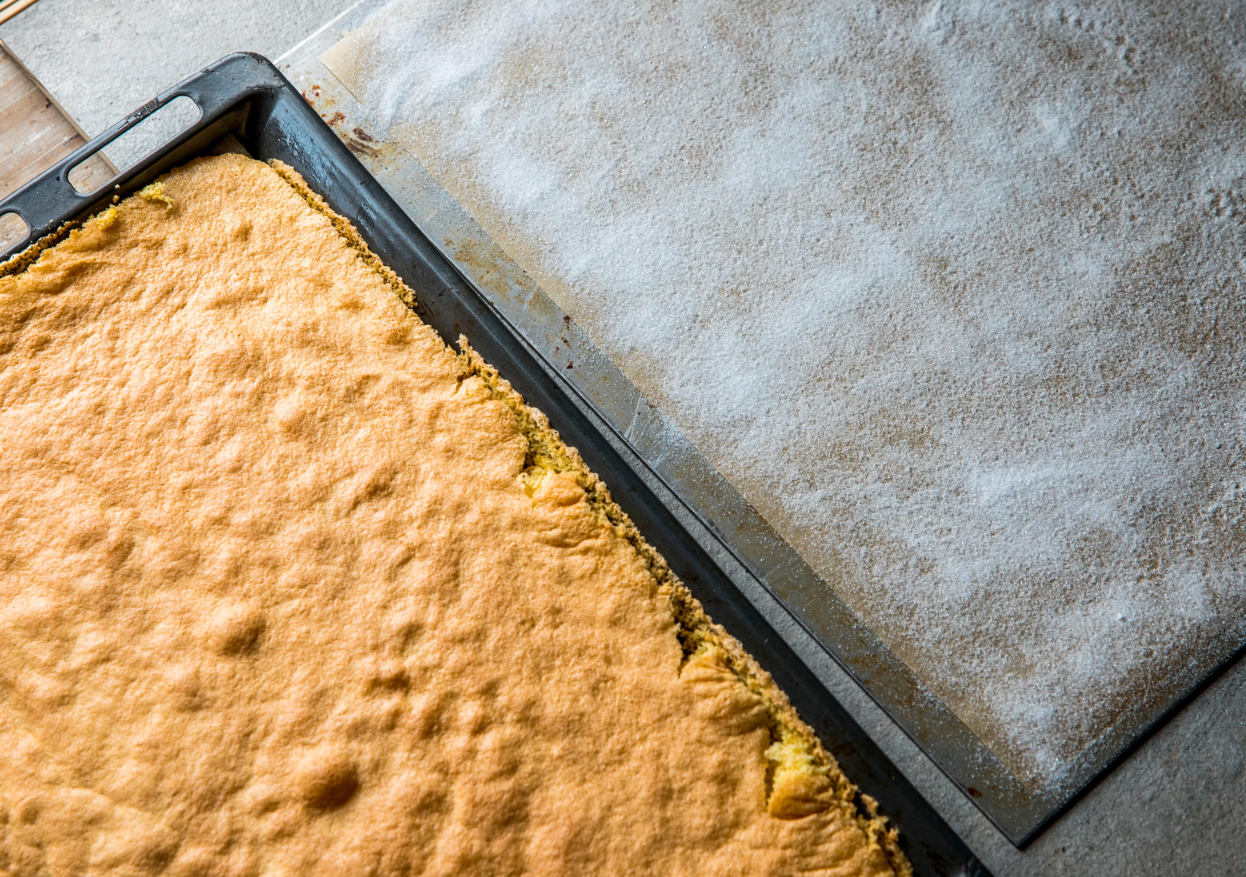 Dryss et et jevnt lag sukker på et ark bakepapir, som er minst like stort som kaken. Du kan også bruke et kjøkkenhåndkle. 