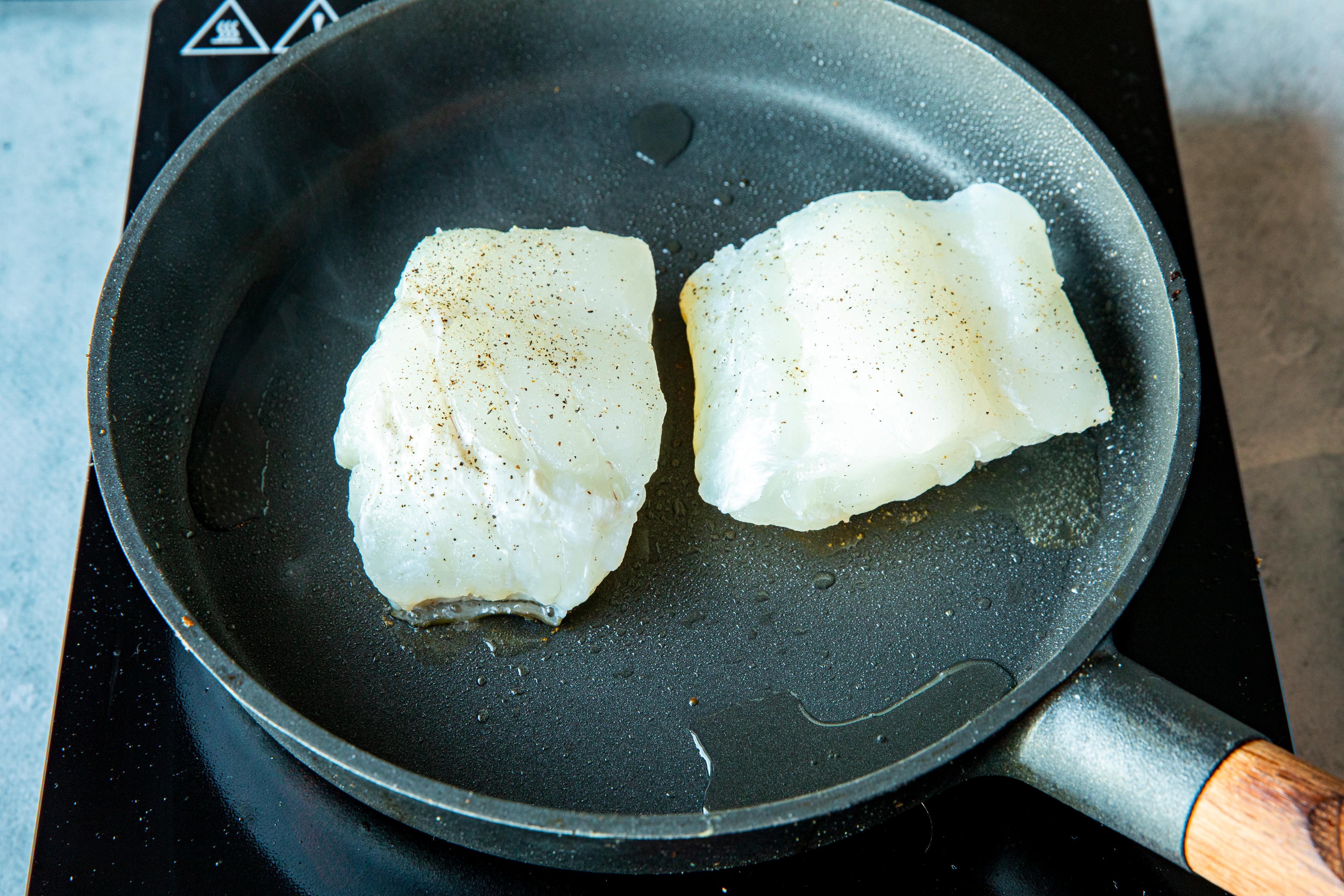 Ha litt olje i en stor og varm stekepanne. Legg i fiskestykkene med skinnsiden ned i pannen. Stek på skinnsiden i cirka 5 minutter over middels høy varme.