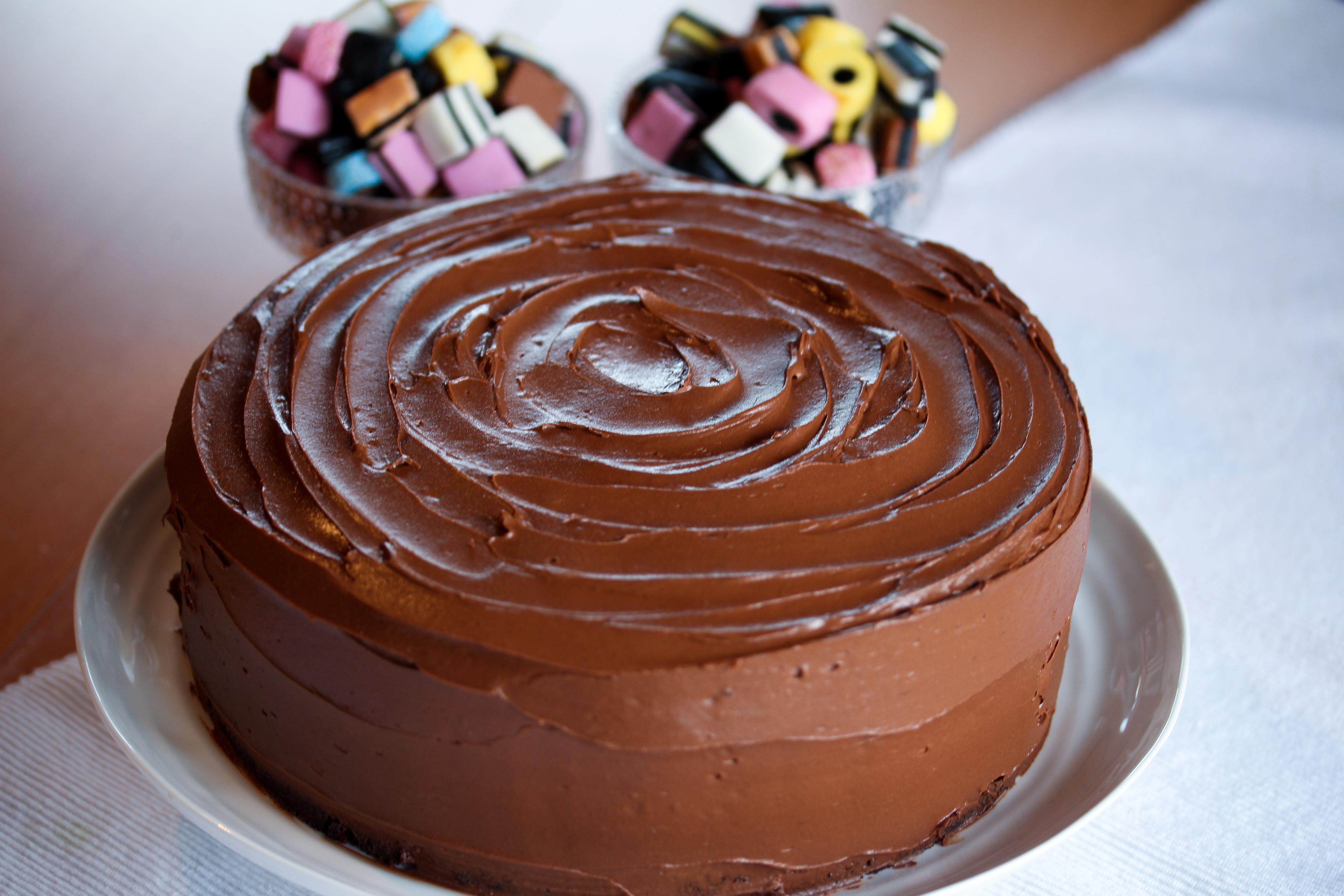 Fordel sjokoladekremen mellom kakebunnene og rundt hele kaken.
