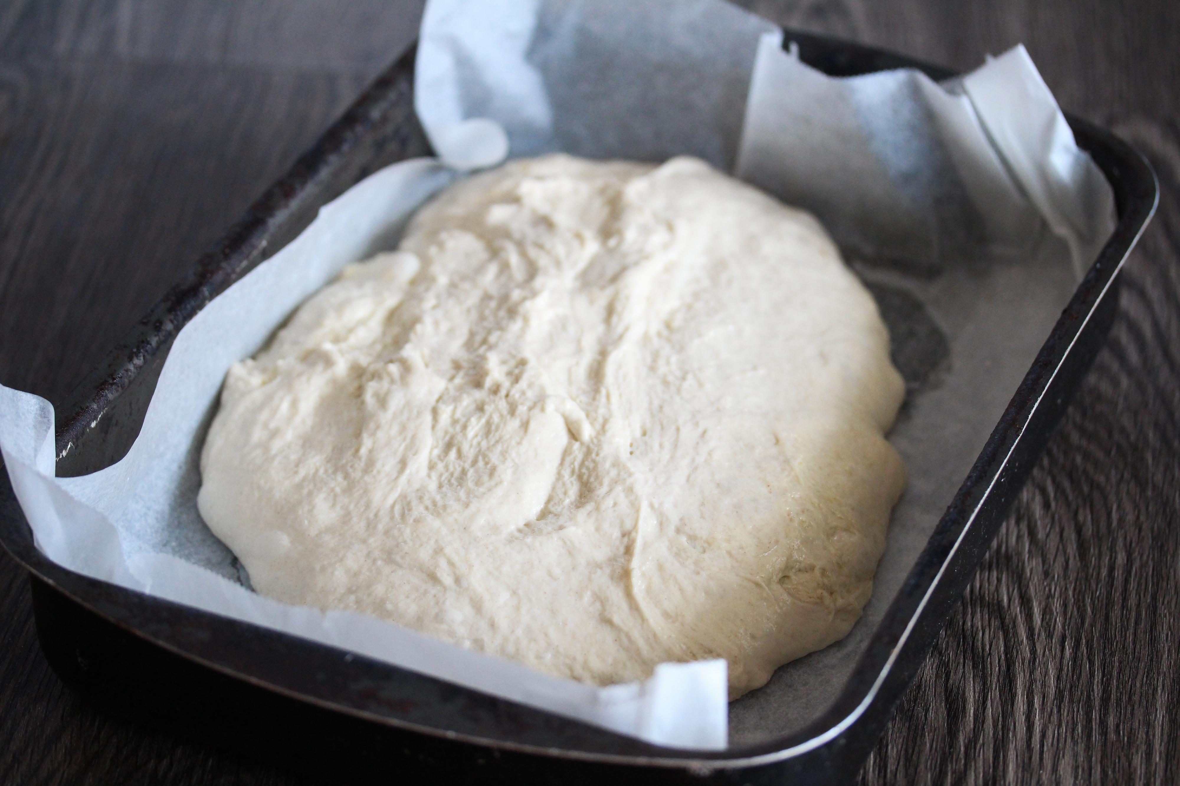 Finn frem en liten langpanne (cirka 20 x 30 cm) og dekk den med bakepapir. Løsne deigen fra kanten av bakebollen med en slikkepott uten å slå ut luften fra deigen. Hvelv deigen direkte fra bakebollen og over i langpanne.