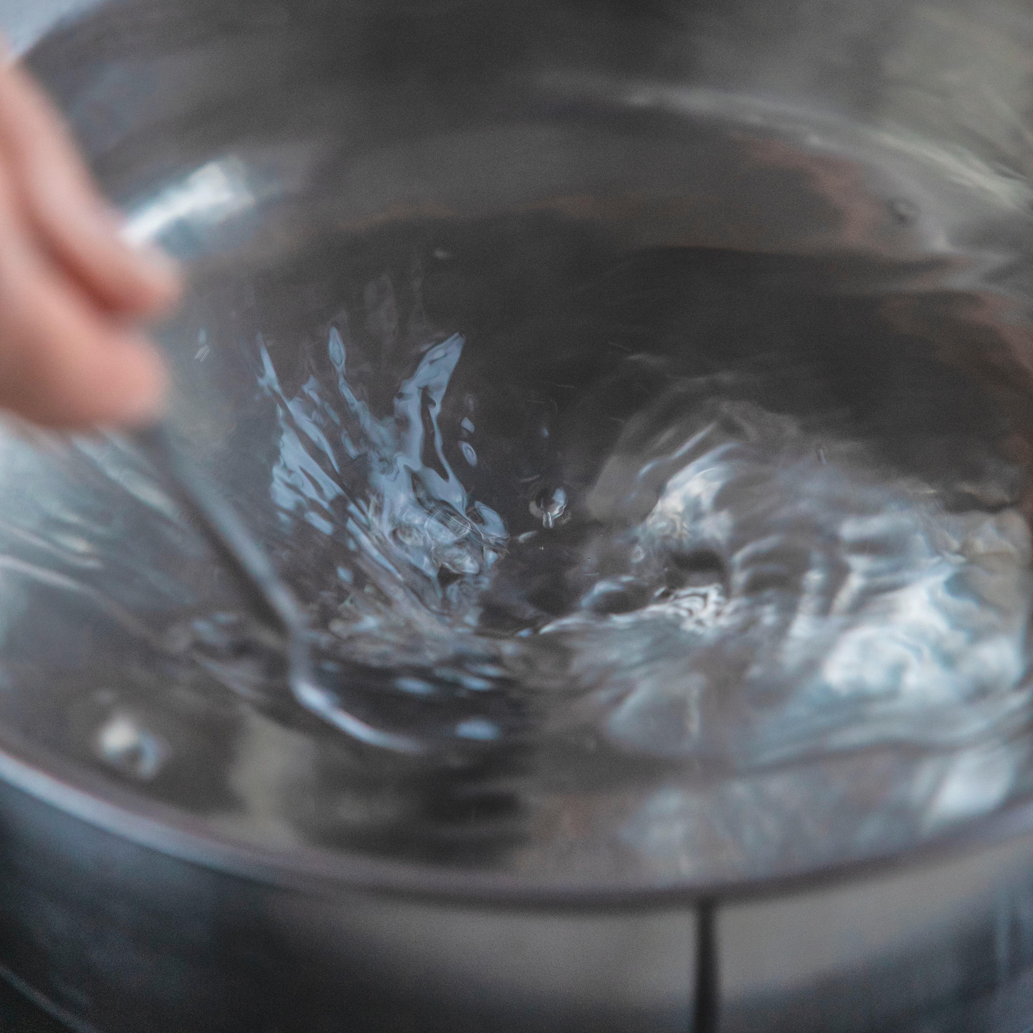 Senk temperaturen på vannet, det skal syde rett under kokepunktet. Rør kraftig slik at det dannes en rotasjon (virvel) i vannet.