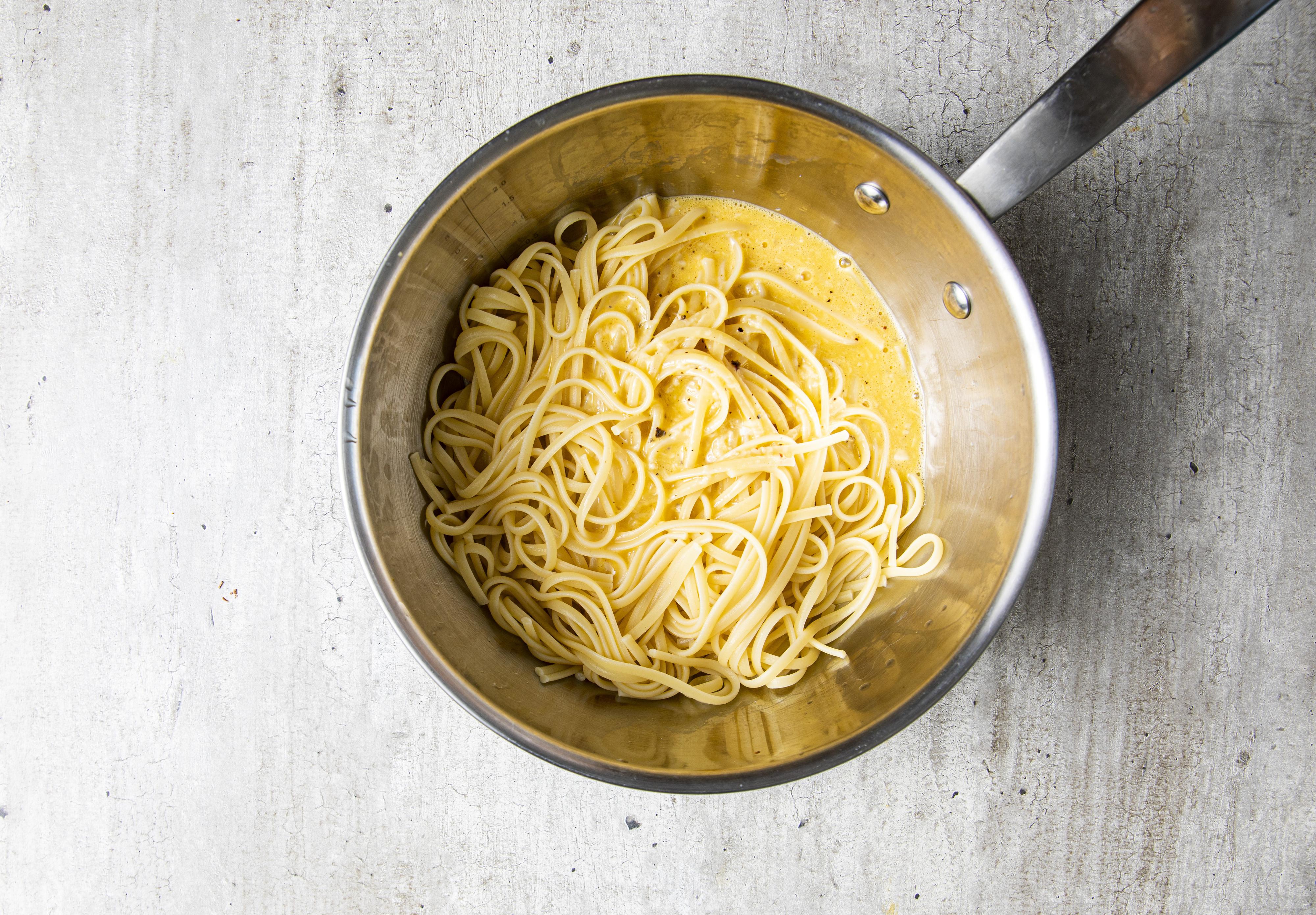 Ha eggeblandingen over i den varme nykokte pastaen. Spe med litt av kokevannet mens du hele tiden rører (eller svinger på kasserollen) til alt er godt blandet. Sausen skal bli saftig, glatt og glinsende (og absolutt ikke kornete). 