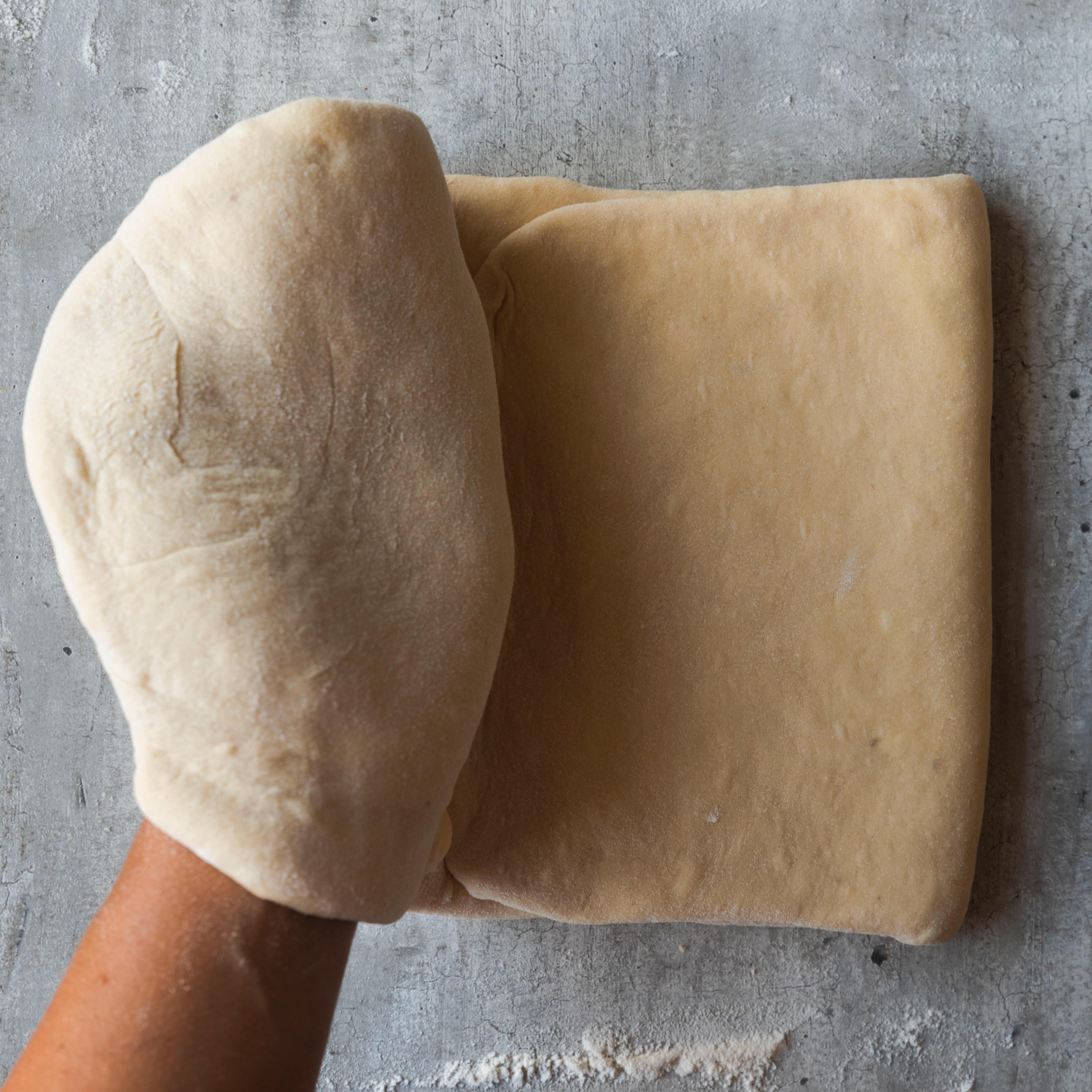 Kjevl deigen på nytt ut til en 1 cm tykk avlang leiv. Brett deigen sammen så du får tre lag.