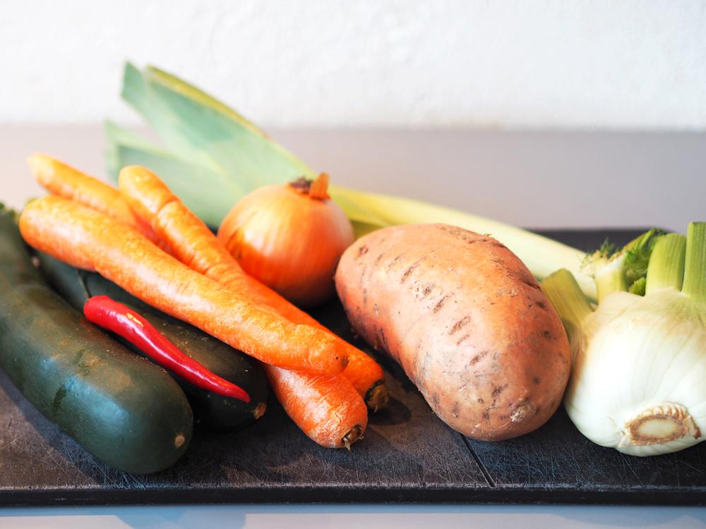 Start med å gjøre klar alle grønnsakene på forhånd. Finhakk hvitløk, chili og løk. Kutt purreløken i ringen. Del søtpotet, gulrot, fennikel og squash i grove terninger. Del brokkolien i buketter.