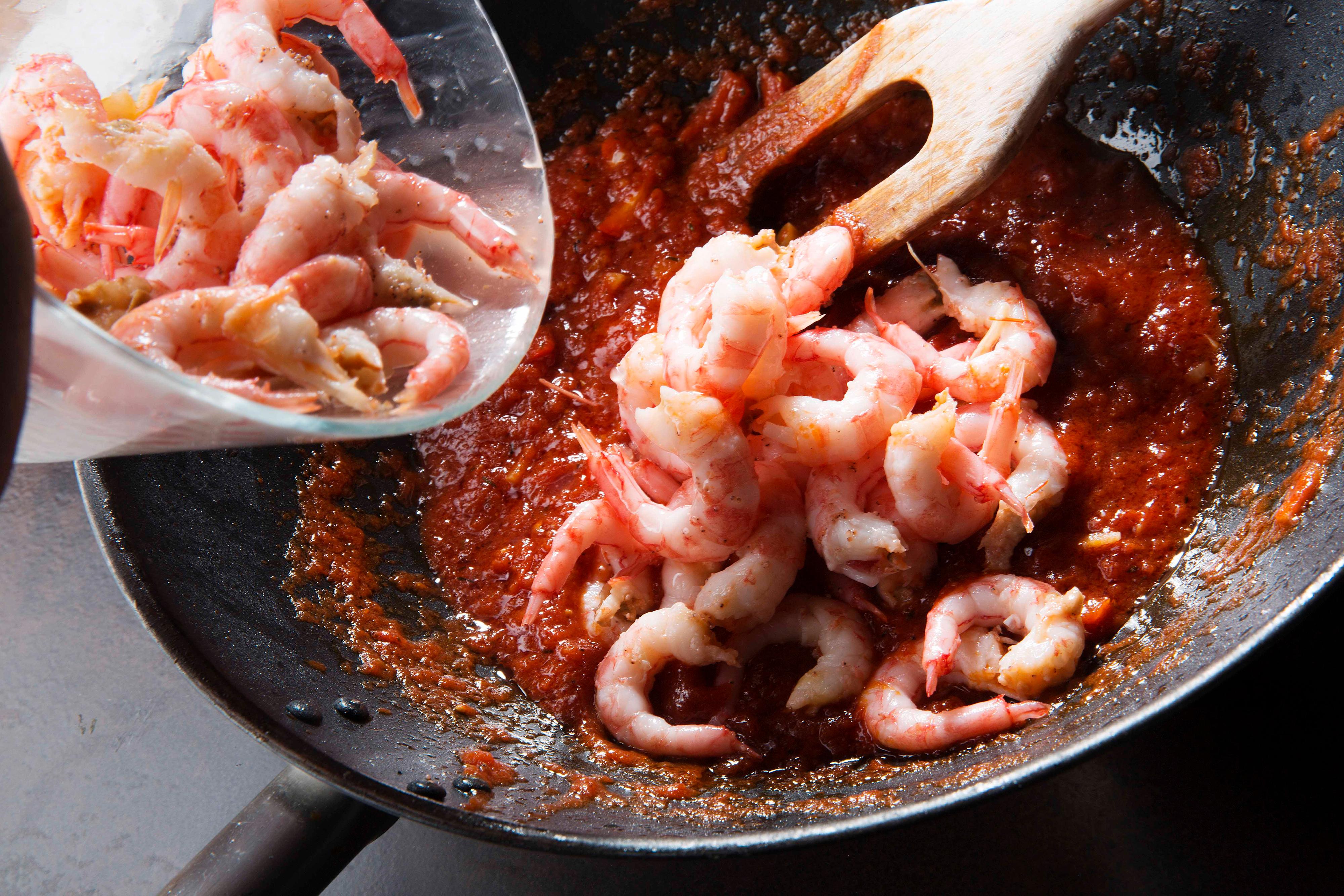 Varm olje i en kjele, fres finhakket hvitløk og paprikabiter raskt før hermetiske tomater tilsettes. Ha i krydderblandingen og la sausen småkoke i 8-10 minutter. Ta kjelen bort fra varmen og ha i rensede reker. Når rekene er varmet i sausen tilsettes finhakket koriander.