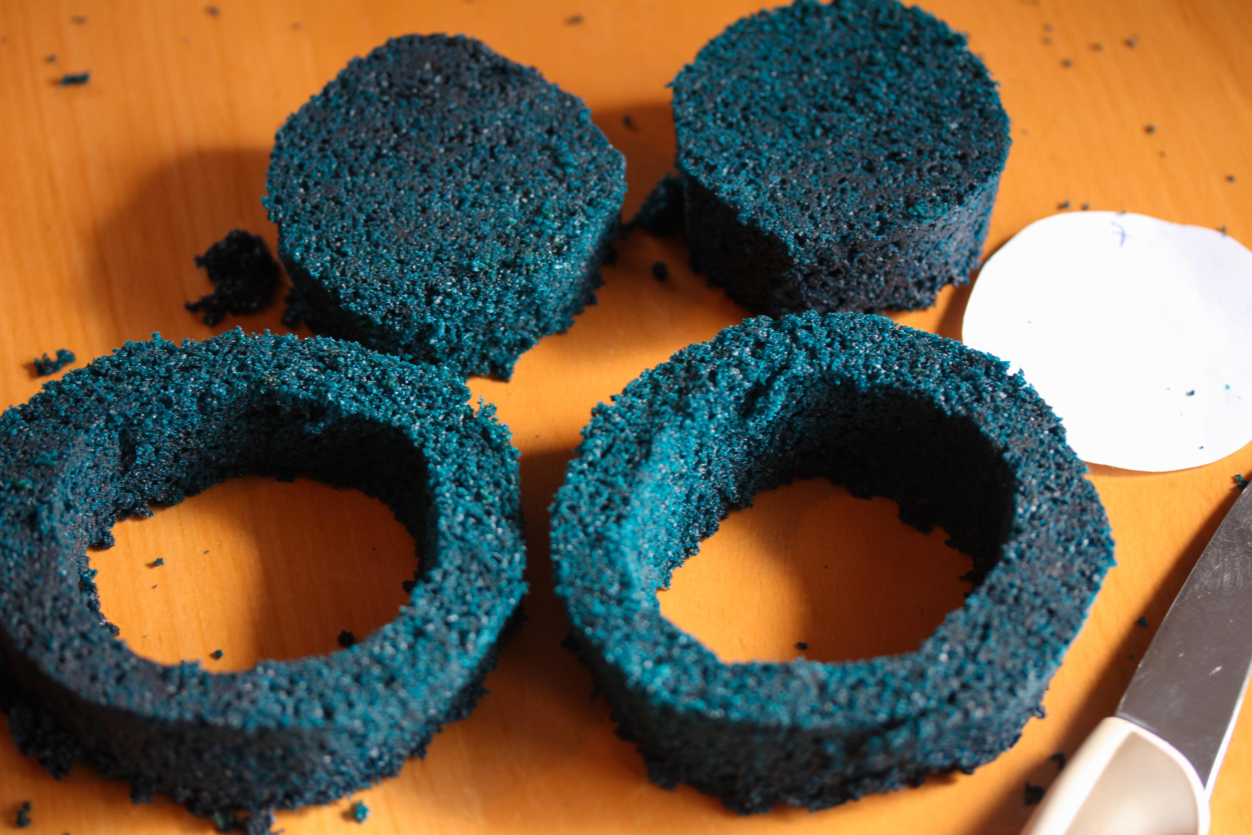 Papirsirklene som er på 7 cm og 10 cm brukes til å beskjære den tykke, blå kakebunnen. Den tynne, blå kakebunnen skal ikke beskjæres. Skjær ut to runde kaker som er 10 cm i diameter. Legg papirsirkelen som måler 7 cm på hver av de to kakene som nå er på 10 cm i diameter og skjær rundt. 