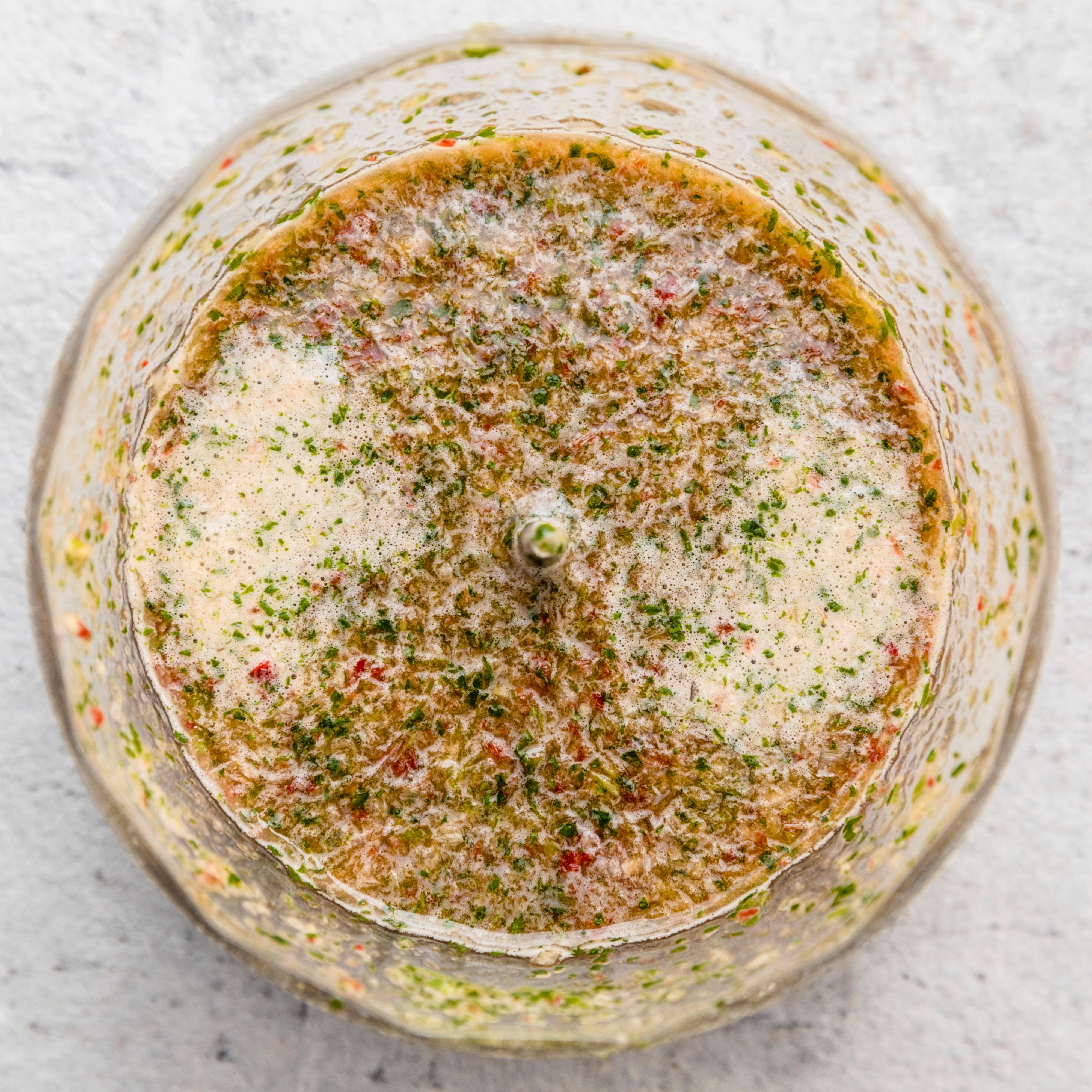 Hakk vårløk, hvitløk og chili. Bruk en liten hurtigmikser eller stavmikser og vårløk, hvitløk, ingefær, chili, lime, sukker, fiskesaus og koriander sammen til en jevn saus.